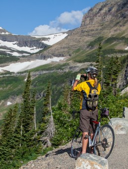 Bicyclist making a photograph at Glacier National Park